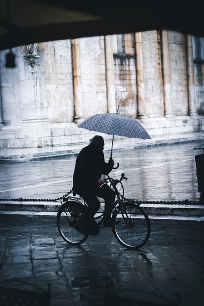 男子骑自行车当伞街附近
